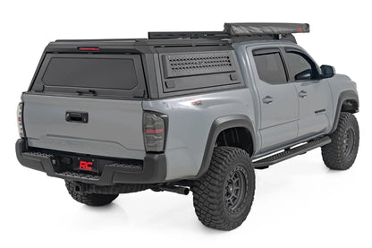 Gray pickup truck with a roof rack on a white background