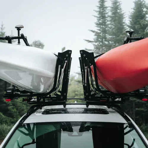 MOS UpLift™ Universal Lift Assist Rack System installed on a car with trees in the background and kayaks with bikes loaded on to it