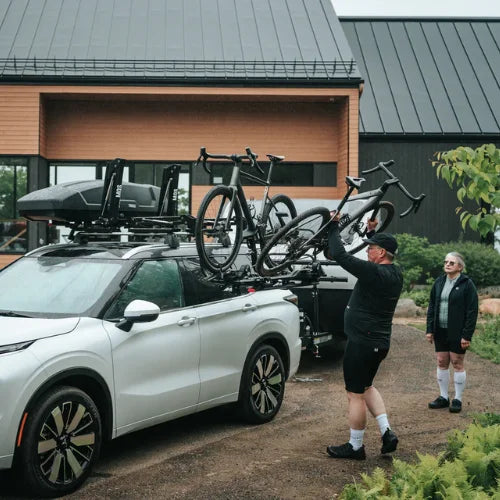 MOS UpLift™ Universal Lift Assist Rack System installed on a car with cottage in the background and roof cargo box with bikes loaded on to it