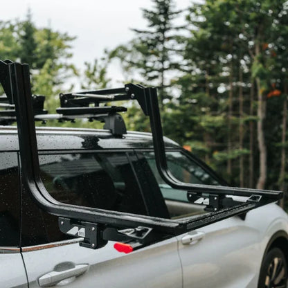MOS UpLift™ Universal Lift Assist Rack System installed on a car with trees in the background and it is tilted down ready to be loaded