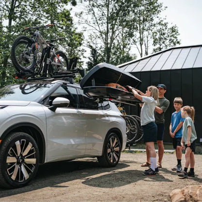 MOS UpLift™ Universal Lift Assist Rack System installed on a car with cottage in the background and with someone loading the cargo box which is tilted down