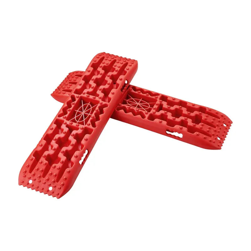 Side view of red recovery traction boards stacked, displaying large cleats and rugged construction.