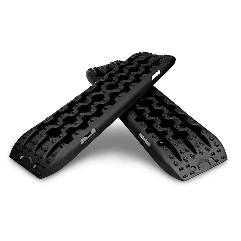 Alternate angle of black recovery traction boards crossed on white background.