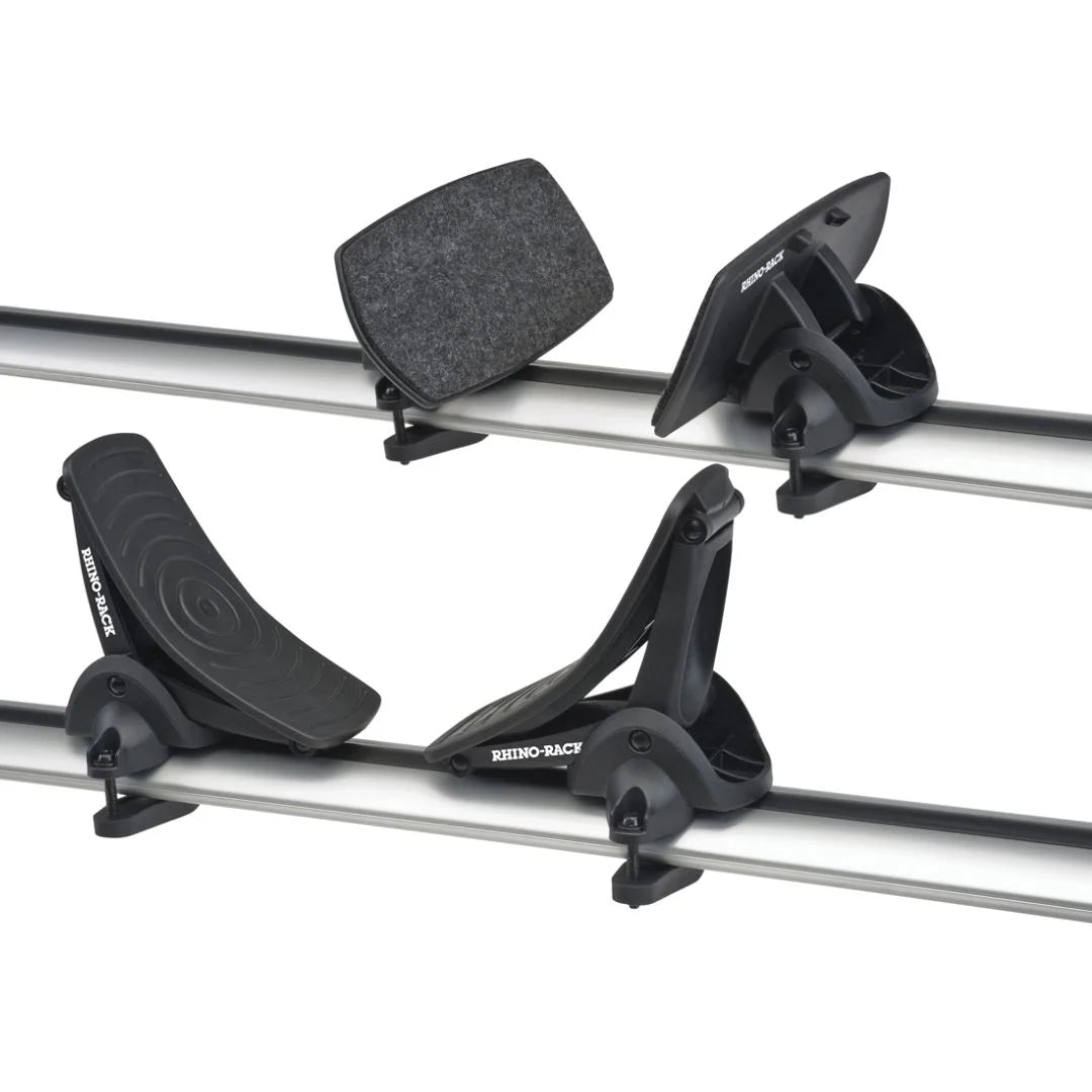 Close-up of Rhino-Rack Nautic 571 kayak carrier cradles mounted on crossbars, showing both front rubber and rear felt-padded supports.