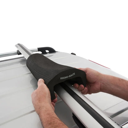 Person installing Rhino-Rack Vortex Foam Wrap Pad onto vehicle crossbar.