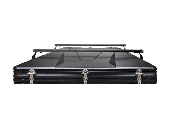 Black 6-channel crossbars mounted on top of a hard shell rooftop tent, shown from the front on a white background.