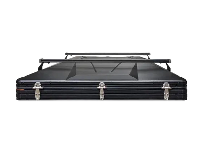 Black 6-channel crossbars mounted on top of a hard shell rooftop tent, shown from the front on a white background.