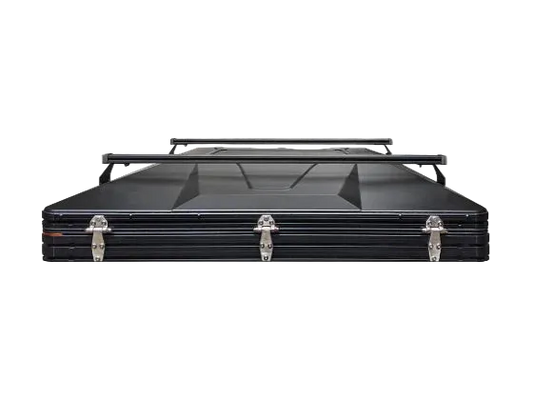 Black 6-channel crossbars mounted on top of a hard shell rooftop tent, shown from the front on a white background.