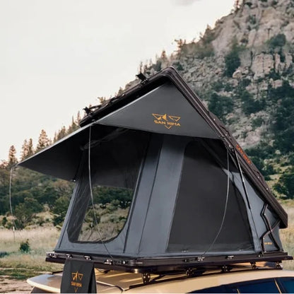 Roof top tent on a vehicle with mountains and trees in the background