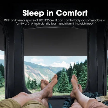 People relaxing inside a rooftop tent with a scenic view of mountains and trees.