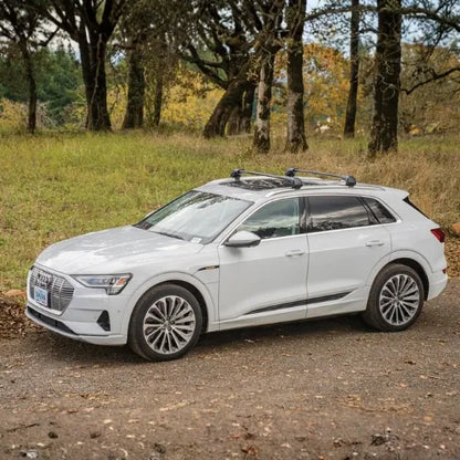 White SUV parked on a dirt road with trees in the background