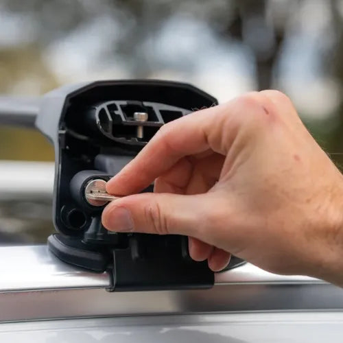 Hand plugging a charging cable into a car's charging port.