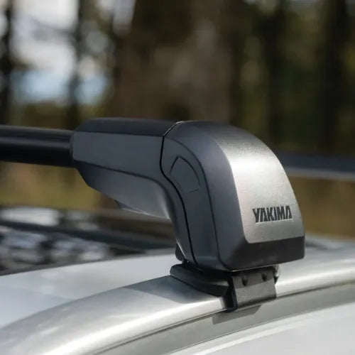 Yakima roof rack mounted on a vehicle with a blurred natural background