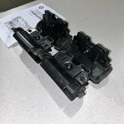 Black mechanical component on a light gray surface with a white paper underneath.
