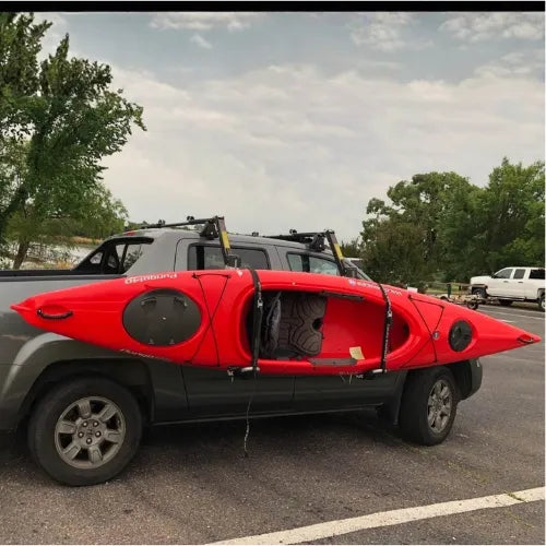 Thule Hullavator Pro  Red kayak on a truck bed with trees and sky in the background