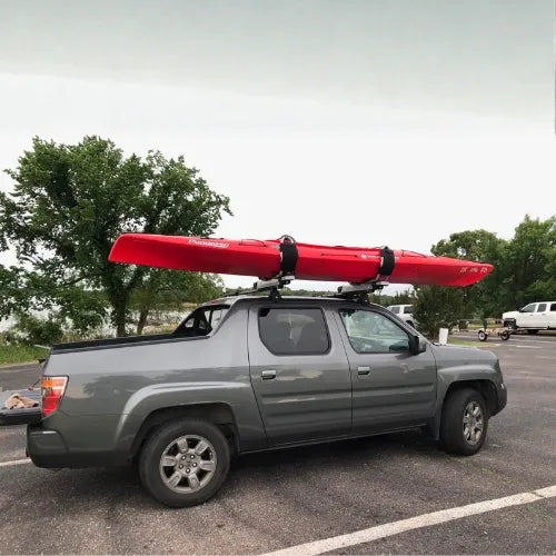 Thule Hullavator Pro  Gray truck with a red kayak on the roof in a parking lot.