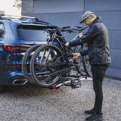 User adjusting rack arms for e-bike mounting