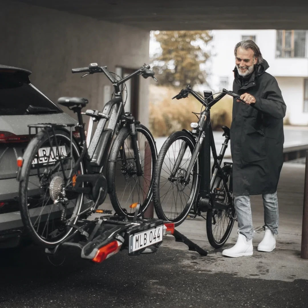 Person mounting bikes onto the Thule Epos rack in a garage