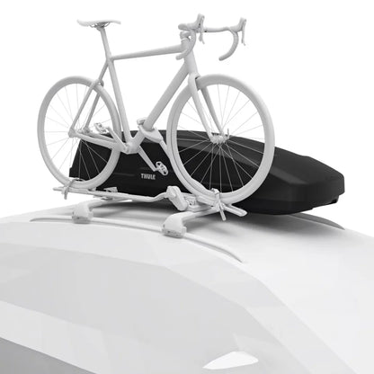 White road bike mounted beside the Thule Force XT Sport cargo box on a white car’s roof.