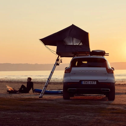 Thule Tepui Foothill Rooftop Tent set up on car parked on ocean in sunset
