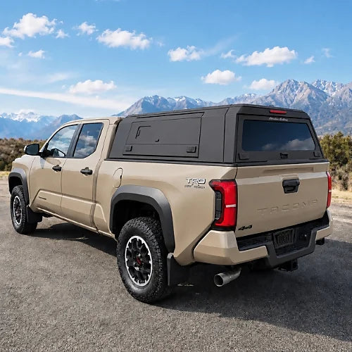 Black aluminum truck cap with tinted rear glass and reinforced side doors on an off-road pickup truck with sliding windows truck cap