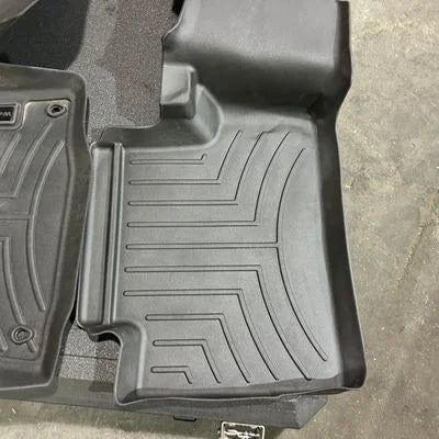 Black car floor mats on a concrete floor