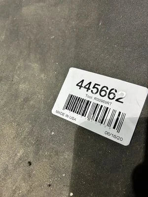 Product tag with a barcode and text on a gray surface