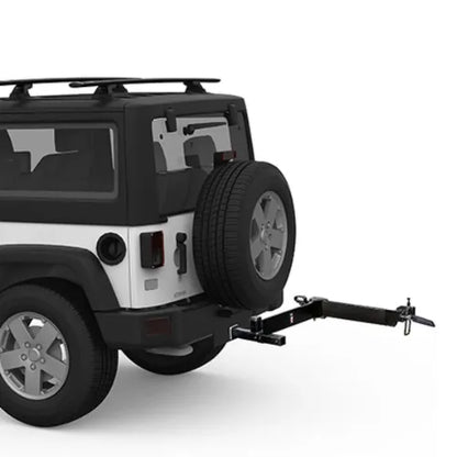 Black and white SUV with a spare tire on the back and a hitch attached, on a white background