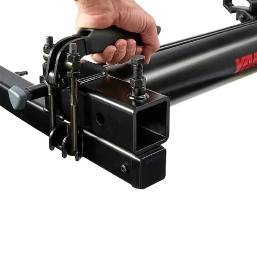 Close-up of a hand adjusting a black hitch receiver on a white background