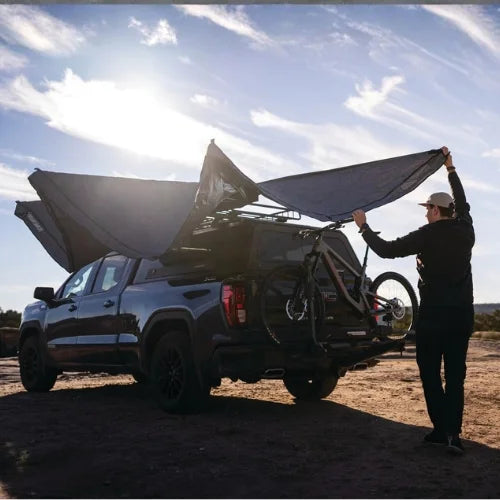 Yakima OverNOut 270 freestanding rooftop awning being deployed on overlanding pickup truck, creating shaded outdoor shelter for camping and adventure travel in Canada