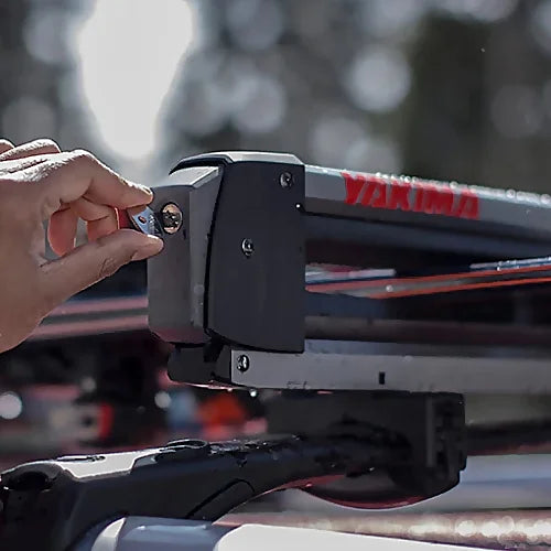 Person locking Yakima FreshTrack ski rack with included SKS key system.