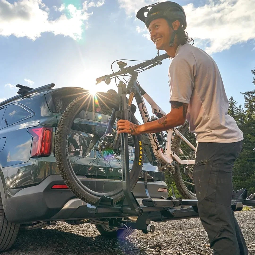 Yakima StageTwo person fixing bike on the back of their car. 