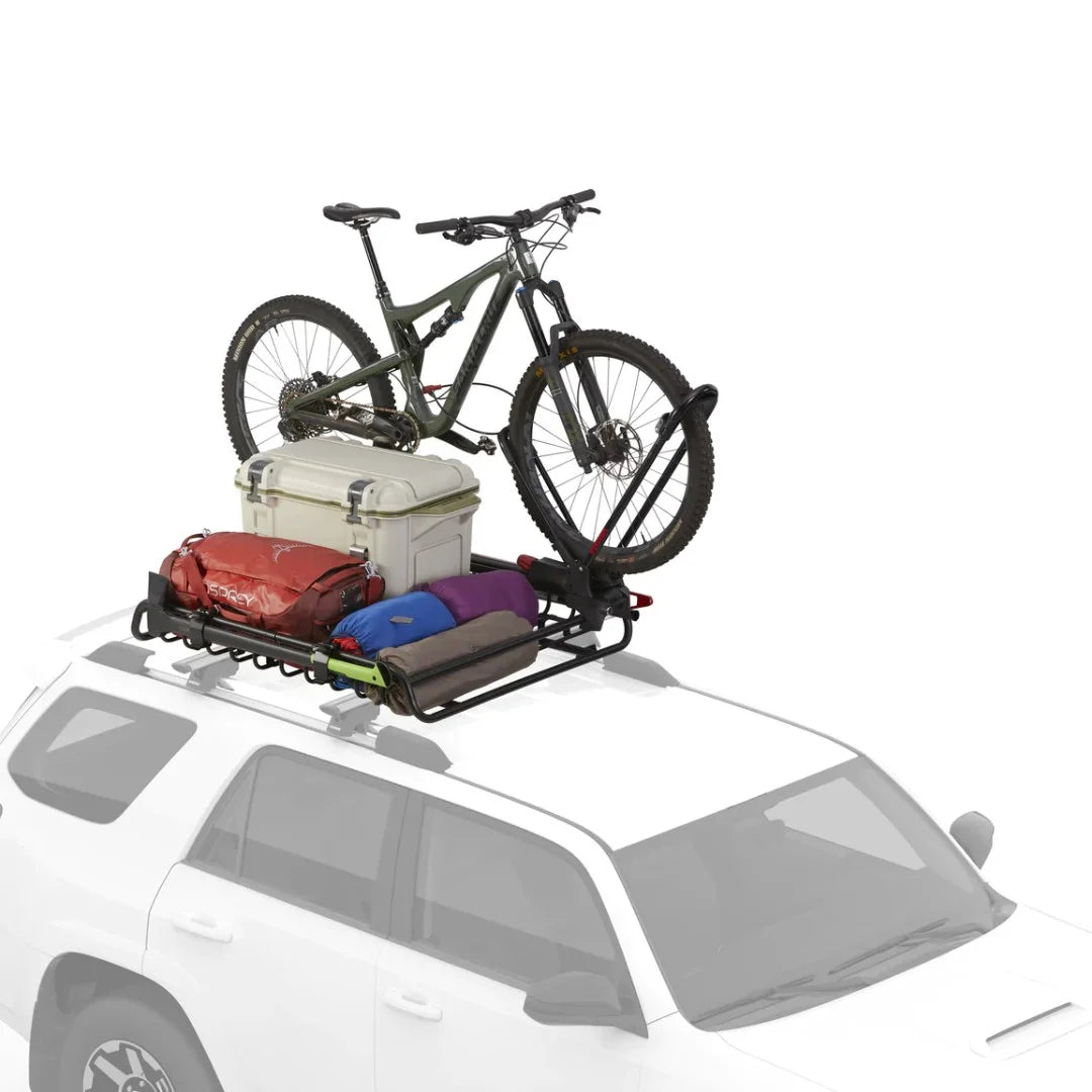 SUV carrying loaded Yakima basket with bicycle and luggage on the roof.

