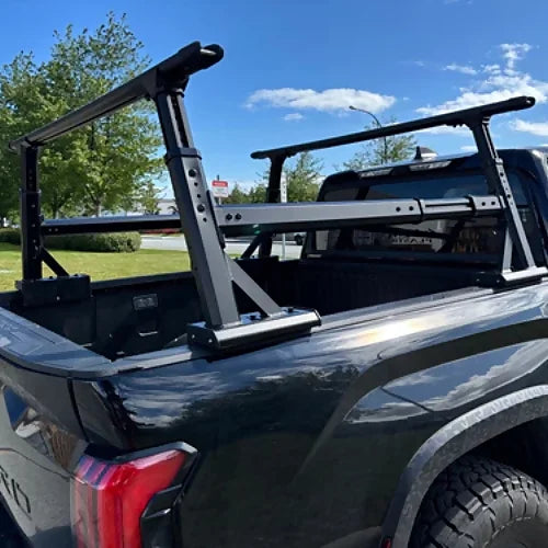 Adjustable stainless steel truck bed rack installed on black pickup, side view