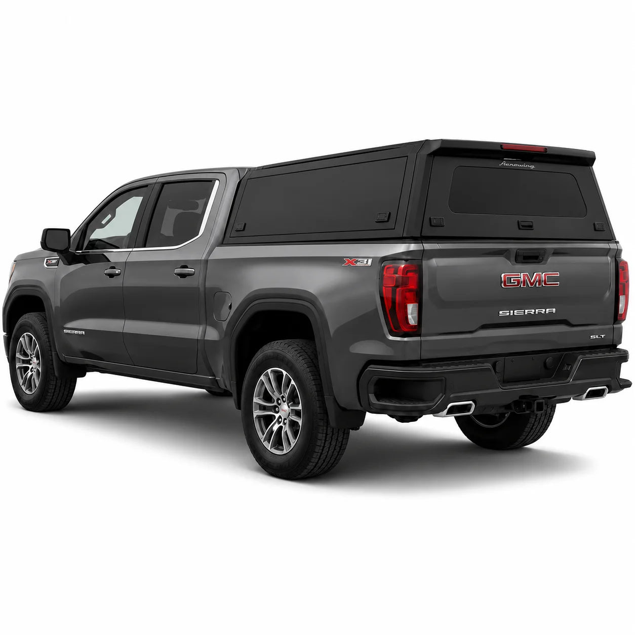 A dark gray GMC Sierra pickup truck with a black hardtop canopy over the bed, shown from a three-quarter rear angle on a white studio background.