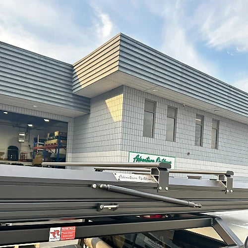 Close-up side view of rooftop tent with adjustable aluminum crossbars