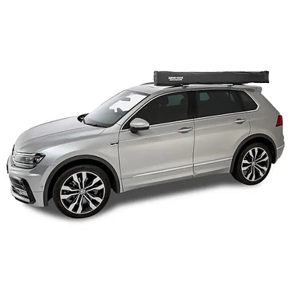 Closed Rhino-Rack Batwing Compact Awning mounted on side roof rack of SUV