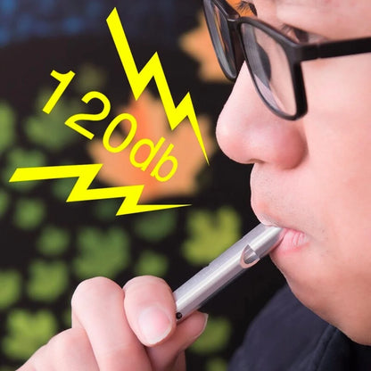 Person blowing AO emergency whistle with “120 dB” text indicating loudness
