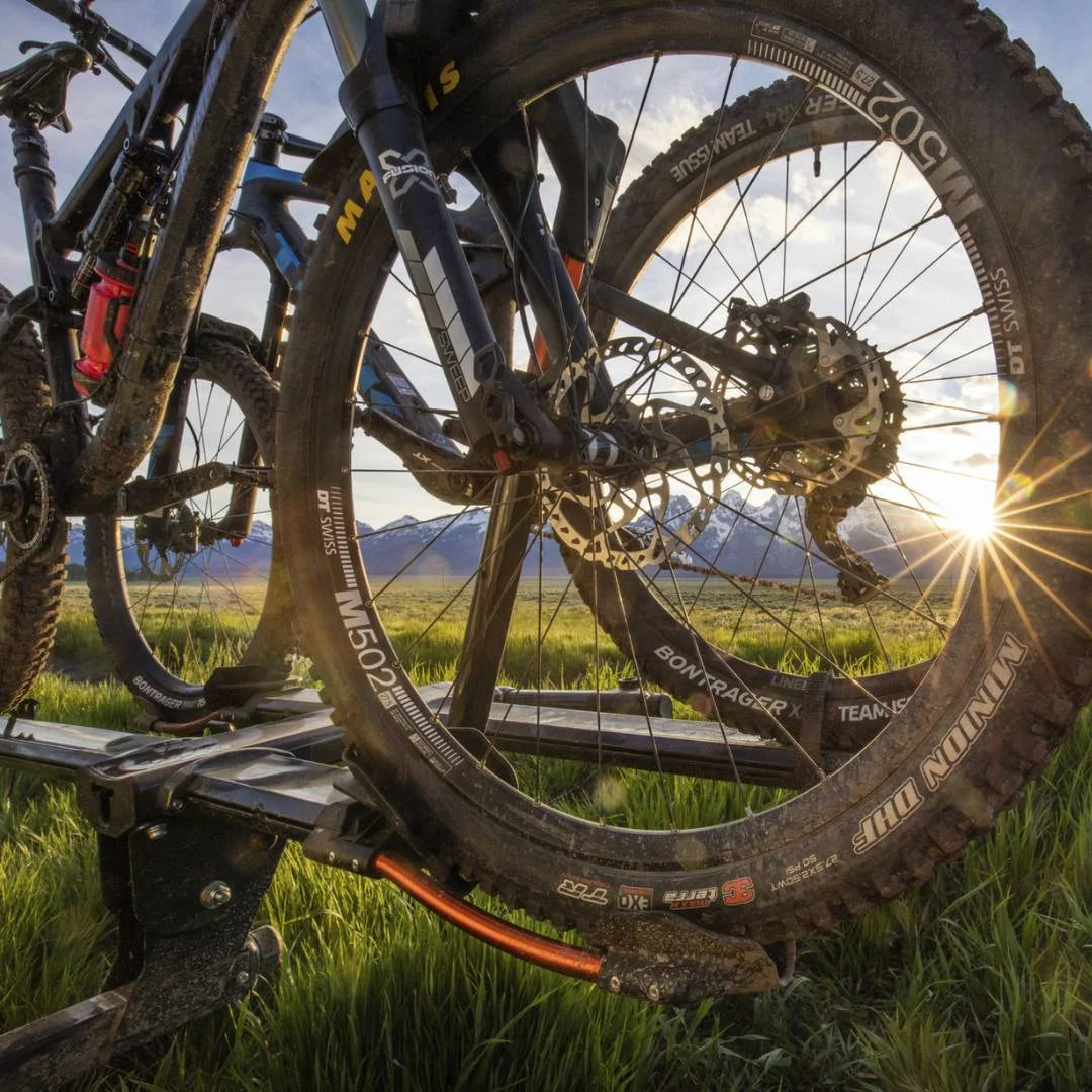 Kuat NV 2.0 holding two bikes during a golden-hour outdoor adventure.
