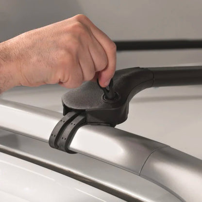 Hand securing crossbar mount onto roof rail during installation.