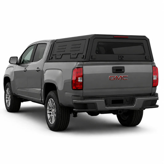 A gray GMC pickup truck shown from a rear three-quarter angle, fitted with a black hardtop canopy over the bed, on a clean white background.