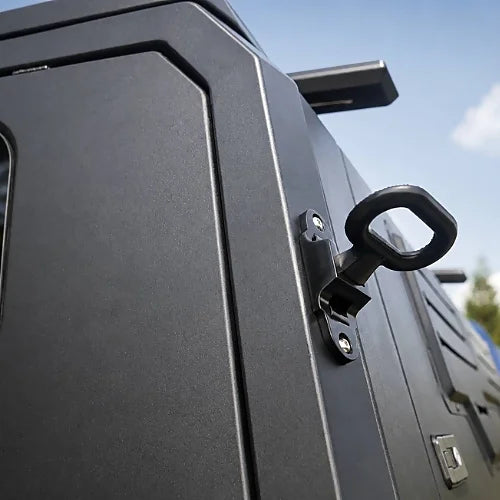 Close-up of secure locking latch and key on black aluminum gullwing truck cap side door 