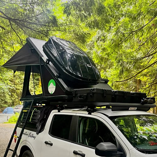 Rooftop tent in open position with cargo box and mounted aluminum bars on white truck
