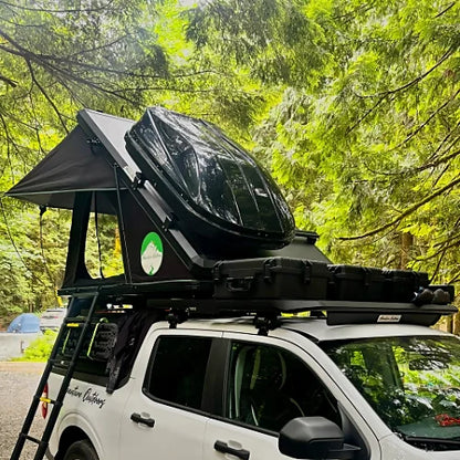Rooftop tent in open position with cargo box and mounted aluminum bars on white truck