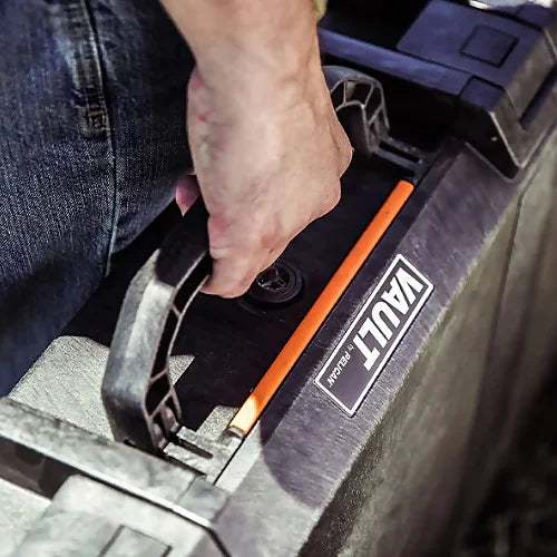 Closeup of hand holding Pelican V700 Vault Case carry handle