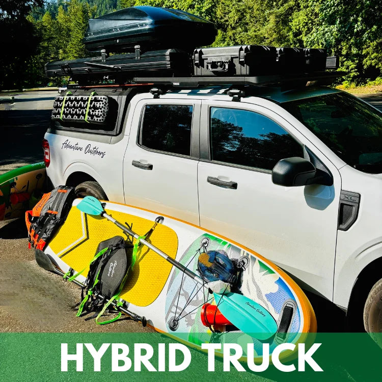 White hybrid truck for rent with roof rack and paddleboard on a road with trees in the background