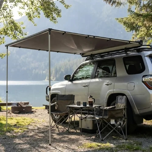 ReTract AO hard case auto retractable car awning extended beside an SUV at a lakeside campsite
