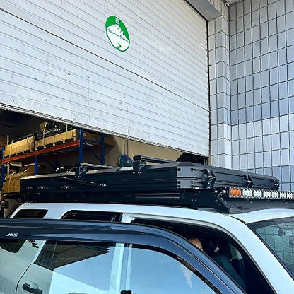 Urban rooftop bar installation with rooftop tent on white SUV in front of garage