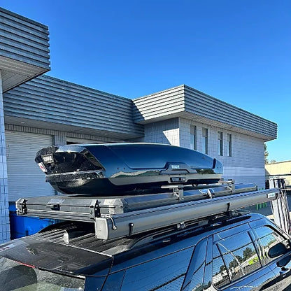 Black roof cargo box mounted on crossbars over rooftop tent