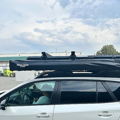 Rooftop tent with mounted roof bars and awning installed on a crossover SUV